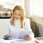 A candid shot of a woman busy with her calculator.