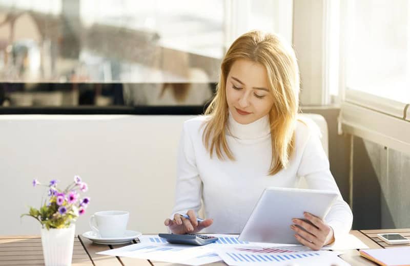 A candid shot of a woman busy with her calculator.