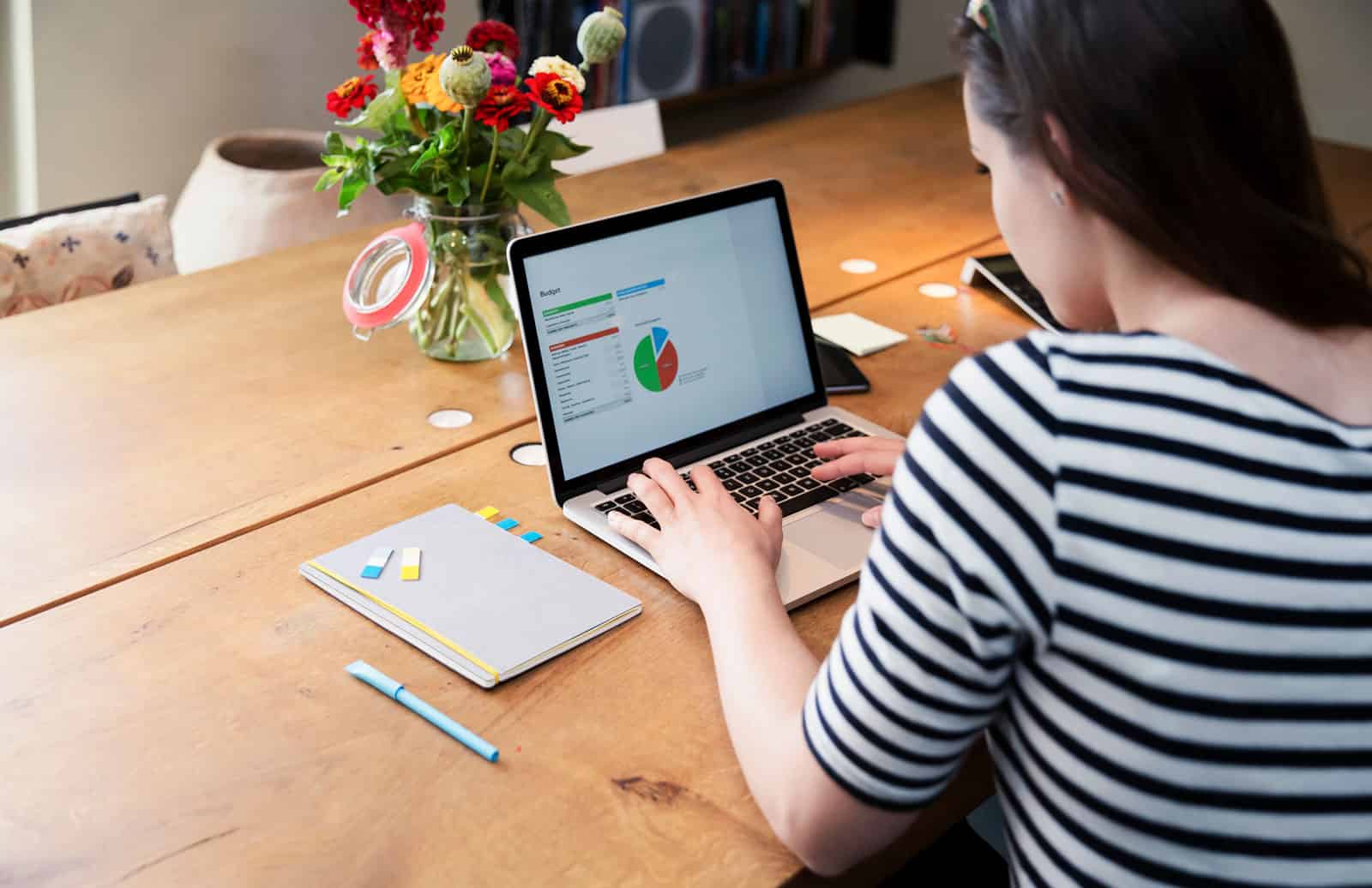 A photograph of a woman's sitting while focusing on her computer.