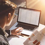 Young banking finance analyst in eyeglasses working at sunny office.